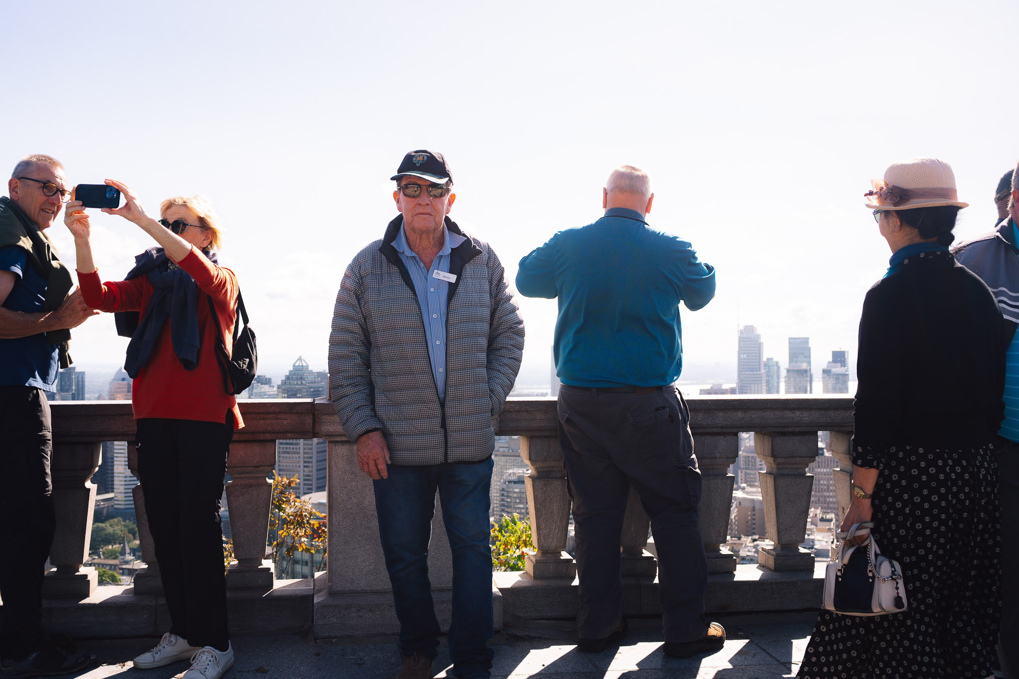 Tour group at a stone balustrade taking photos of the city skyline