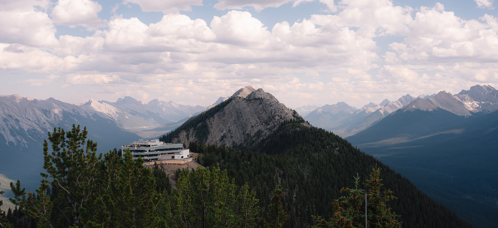 Gondola summit building perched on a ridge among rows of mountains